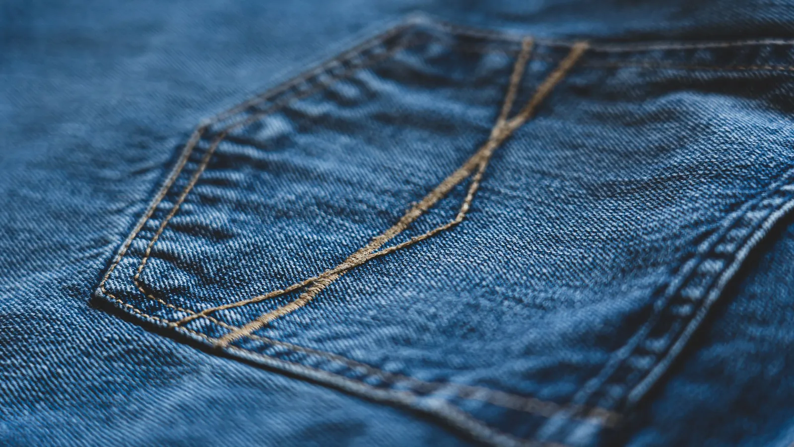 Close-up of blue denim jeans showing pocket stitching